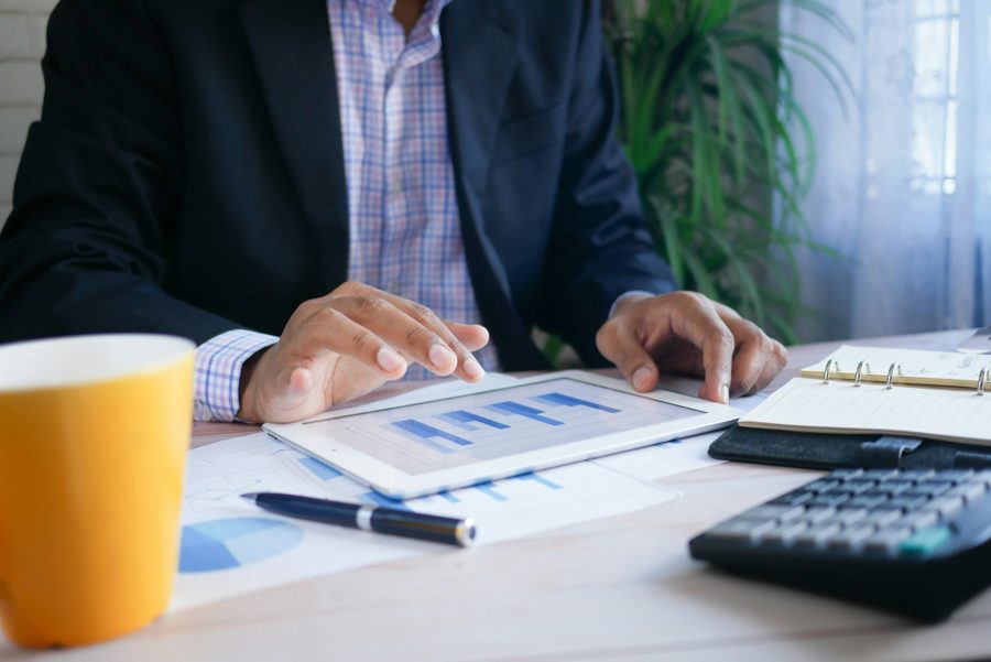 Ejecutivo revisando gráficos financieros en una tableta